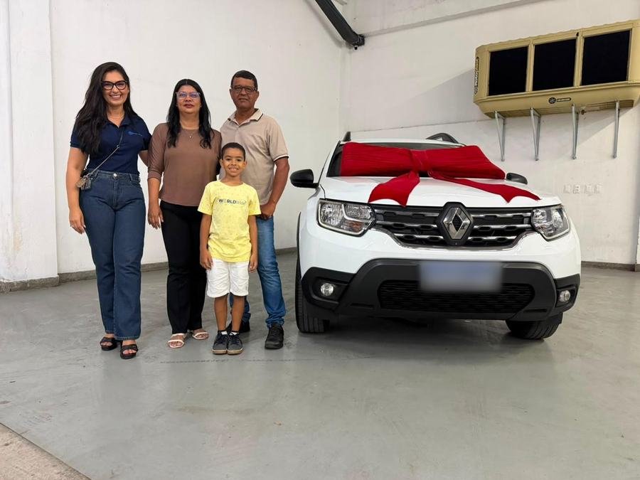 Família ao lado da Mariana na entrega de um Renault Duster branco